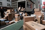 Dozens of packages are lined up along a Manhattan street as a FedEx truck makes deliveries on Dec. 6, 2021, in New York City.