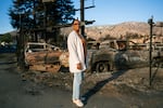 Veronica Jones, the Altadena Historical Society's first Black president, stands in front of a lot full of burned cars on January 21, 2025. The Eaton Fire came just a block away from her home in west Altadena.
