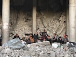 A family sits in a destroyed building in Rafah on Jan. 25, 2025.