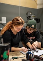 In a photo provided by Central Oregon Community College, Avery Smith (left) and Sydon Kofal use a micrometer to measure a part in a manufacturing processes class in the manufacturing technology lab in Redmond, Ore., in November 2024.