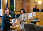 Deputy prosecutor Melinda McMahon hands defense attorney Jon McMullen an item submitted into evidence Tuesday, April 15, 2025, during a trial at Clark County Courthouse. The state accuses Alicia Stowe of having a sexual relationship with a minor patient while she was a counselor at Daybreak Youth Service’s Brush Prairie facility. 