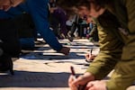 HARTFORD, CONNECTICUT, MARCH 28, 2026: Thousands sign a banner that says “We the People” at the “No Kings” protest at the capitol in Hartford on March 28, 2026. (Tyler Russell/Connecticut Public)
