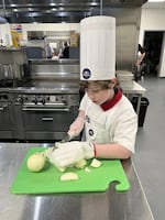 Milo Springer chops onions for his G.O.A.T-o risotto.