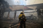 A firefighter extinguishes the remains of a hardware store destroyed in the Eaton fire in Altadena, California, on Wednesday.