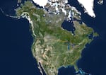 A satellite map of North America, highlighting the U.S.-Canada boundary line.