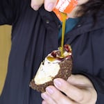 A mango jalapeño sauce gets drizzled on a Salt & Straw Tacolate on Oct. 2, 2025. The ice creamery worked with Taco Bell on branding and innovation, including the faux "hot sauce" packets.