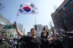 People react after hearing the news that President Yoon Suk Yeol was removed from office, in Seoul, South Korea, Friday, April 4, 2025.