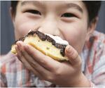 Rachel Yang's older son, Pike Chirchi, 7, takes a bite of Upside-Down Fig Mochi Cake with Bleu Cheese Whip. The sweet-savory "dessertish" rice cake can be made with dried apricots instead of Mission figs.