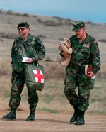 FILE - Norman Olson, right, Michigan militia leader, carrying a stuffed animal and a Bible, walks with militia member Ray Southwell, who says he's a nurse, as they approach an FBI roadblock to the restricted area around the Montana Freemen's compound outside Jordan, Mont., on April 17, l996. Olson and Southwell were denied entrance to the restricted area. Experts say far-right groups in the U.S. are taking a more dangerously radical turn as four men go on trial in an alleged scheme to kidnap Michigan's governor.
