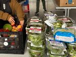 Dozens of boxed salad greens are laid out next to other fresh produce at an Urban Gleaners free food market in an affordable housing complex in Southwest Portland, Ore., on Sept. 21, 2025.