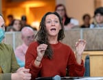 Belle Zaccari of Portland asks pointed questions of Oregon legislators during a town hall at the Federal Building in Portland, Ore., March 17, 2025. Zaccari, a clinical psychologist who has worked more than 10 years as a clinical psychologist for the United States Department of Veterans Affairs, said she has more than $300,000 in student loan debt.