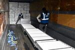 Boxes filled with COVID-19 are loaded into the back of a delivery truck by two people.