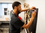 Dennis Jethroe, 50, of Ferguson, writes the name of a loved one on a paper leaf on Tuesday, Aug. 6, 2024, during an art exhibit at the Ferguson Empowerment Center in Ferguson.