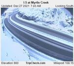 Snow is visible on both sides of a winding highway.