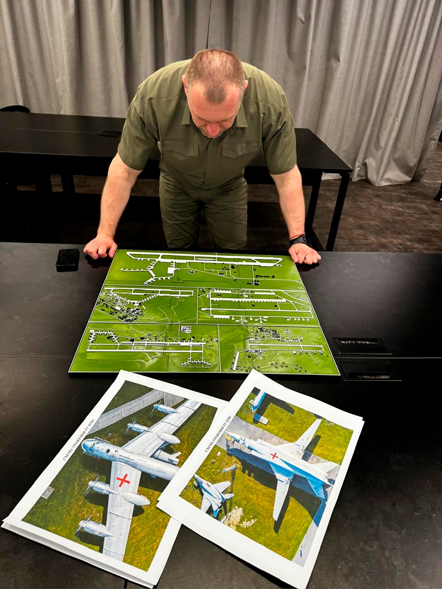 In this undated photo provided by the Ukrainian Security Service, head of the Security Service Vasyl Malyuk studies a photo of a map of Russia's strategic aviation location in his office in Ukraine.