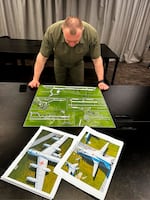 In this undated photo provided by the Ukrainian Security Service, head of the Security Service Vasyl Malyuk studies a photo of a map of Russia's strategic aviation location in his office in Ukraine.