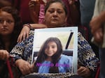 A woman holds a photo of Nevaeh Bravo, who was killed on Tuesday.