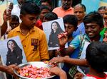 Villagers holding photos of Kamala Harris distribute sweets to celebrate Harris' inauguration as U.S. vice president in January 2021, in Harris' ancestral village of Thulasendrapuram.