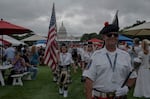 The Indianapolis 500 Gordon Pipers march down the National Mall during the Freedom 250 Grand Prix.