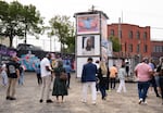 People tour an art installation at one of the sites purchased by 1803 Fund on North Mississippi Avenue and North Interstate Avenue on July 20, 2026, in Portland, Ore. 1803 Fund is investing in several properties in the Albina neighborhood as part of its redevelopment effort.