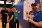 From left, NWS meteorologist Scott Stearns and OMSI camp manager Alysia Downs look at the map of the Rowe Creek Complex Fire at a fire information meeting in Fossil, Ore., on July 21, 2026. Downs said the fires affected land around their property and that OMSI cancelled camp this week as a safety precaution. 
