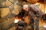 Mike Gudge tends the fire at Steiner Log Church, Rhododendron, Ore., Jan. 11, 2024.