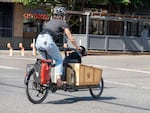 A cargo bike with a black lab in the front.