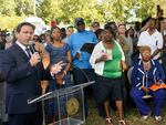 Florida Gov. Ron DeSantis, left, speaks at a prayer vigil on Sunday for the victims of a mass shooting that took place Saturday in Jacksonville, Fla.