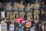 California National Guard soldiers and police stand outside of a federal building as protesters rallied in Los Angeles in June.