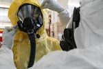 Firefighters Bozeb Beckwith and Kevin Leonard demonstrate the hazmat gear Portland Fire & Rescue might wear when treating potential coronavirus patients.