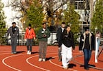 In this photo provided by Talk A Mile, students and police officers walk and talk in pairs around a track in Portland in December 2024.