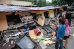 People look at a collapsed building in Bogo City, Cebu province, Philippines Wednesday, Oct. 1, 2025, after an offshore earthquake on late Tuesday.