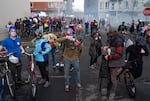 Protesters try to get tear gas out of their eyes and escape the area after federal agents deployed the chemical munition on a crowd of more than a thousand demonstrators, many of whom were with local unions and included elderly people and children, in the blocks surrounding the U.S. Immigration and Customs Enforcement facility on Jan. 31, 2026.