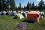 A sign thanking firefighters for their work marks dozens of crews' tents at the base camp for those fighting the Akawa Butte Fire at the Sisters Rodeo grounds in Sisters, Ore., on July 25, 2026.