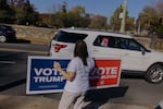 A Republican supporter holds a sign backing presidential candidate Donald Trump for drivers passing by the Staten Island Republican Party headquarters.