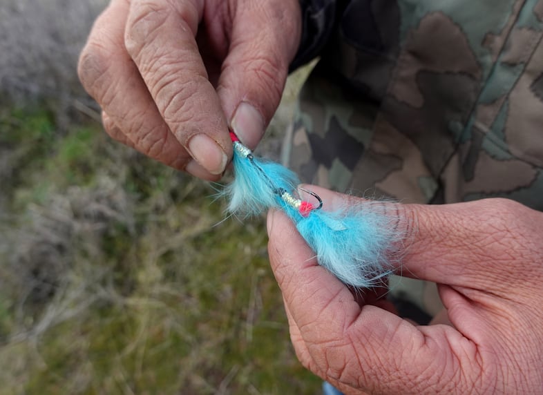 Fly fishing guide Elke Littleleaf holds a lure made of rabbit fur and reflective materials that he says "light up like a Christmas tree for salmon" on the Warm Springs Reservation.