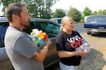 Dustin Bagby, left, and Rachel Williams prepare to hand out water and Gatorade at an encampment in Clackamas, Oregon on Sept. 6, 2024.