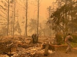 Sam Drevo walks by the burned foundation of his mother’s home in Gates following the 2020 Labor Day fires.