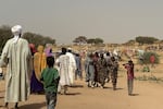 People who fled the Zamzam camp for the internally displaced after it fell under RSF control, walk in a makeshift encampment in an open field near the town of Tawila in war-torn Sudan's western Darfur region on April 13, 2025.