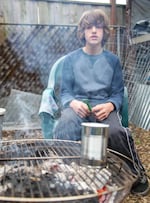Shea Stephens cooks a pancake in a tin can on the Stephens fire in the backyard of their house in North Portland. Over the weekend, the Stephens had to live off what they could find and cook, without using power sources or running water.