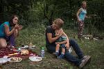 Olga Grinik holds her son, Kirill, during a picnic in a forest on the outskirts of Avdiivka in July 2018, with Olga's sister, Valentina Mountyan (right), and niece, Victoria Mountyan (left).