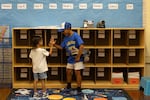 Gerald Gomez-Reina high-fives new kindergartener Ian Patterson after they track down his cubby just before the first day of school at Micheltorena Street Elementary in Los Angeles.