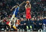 Portland Trail Blazers forward Deni Avdija, right, goes up to shoot over Golden State Warriors forward Draymond Green, left, during the first half of an NBA basketball game in Portland, Ore., Sunday, Dec. 14, 2025.