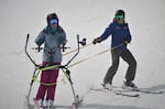 Using a "slider" helps Dana Sherry carve her own turns as she and her instructor Kellie Standish ski the half-pipe at Mt Bachelor.