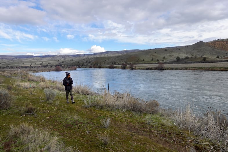 Klick'ump, also known as Alysia Aguilar, walks along a bend of the lower Deschutes River through the Warm Springs Reservation, Feb. 2, 2024, checking on the saplings she and others replanted after wildfires. "It's important for anyone to get involved in any way they can," she says.