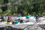 At far left,  ‘A:de’ts-Nikya:w Rogers of the Hoopa Valley Tribe pauses at the beginning of a rapid on the Klamath River while other paddlers wait behind him, June 22, 2025. Rogers and the other kayakers are participants in Paddle Tribal Waters, a program that trained Indigenous youth for several years to be the first group of people to paddle the free-flowing Klamath from source to sea.