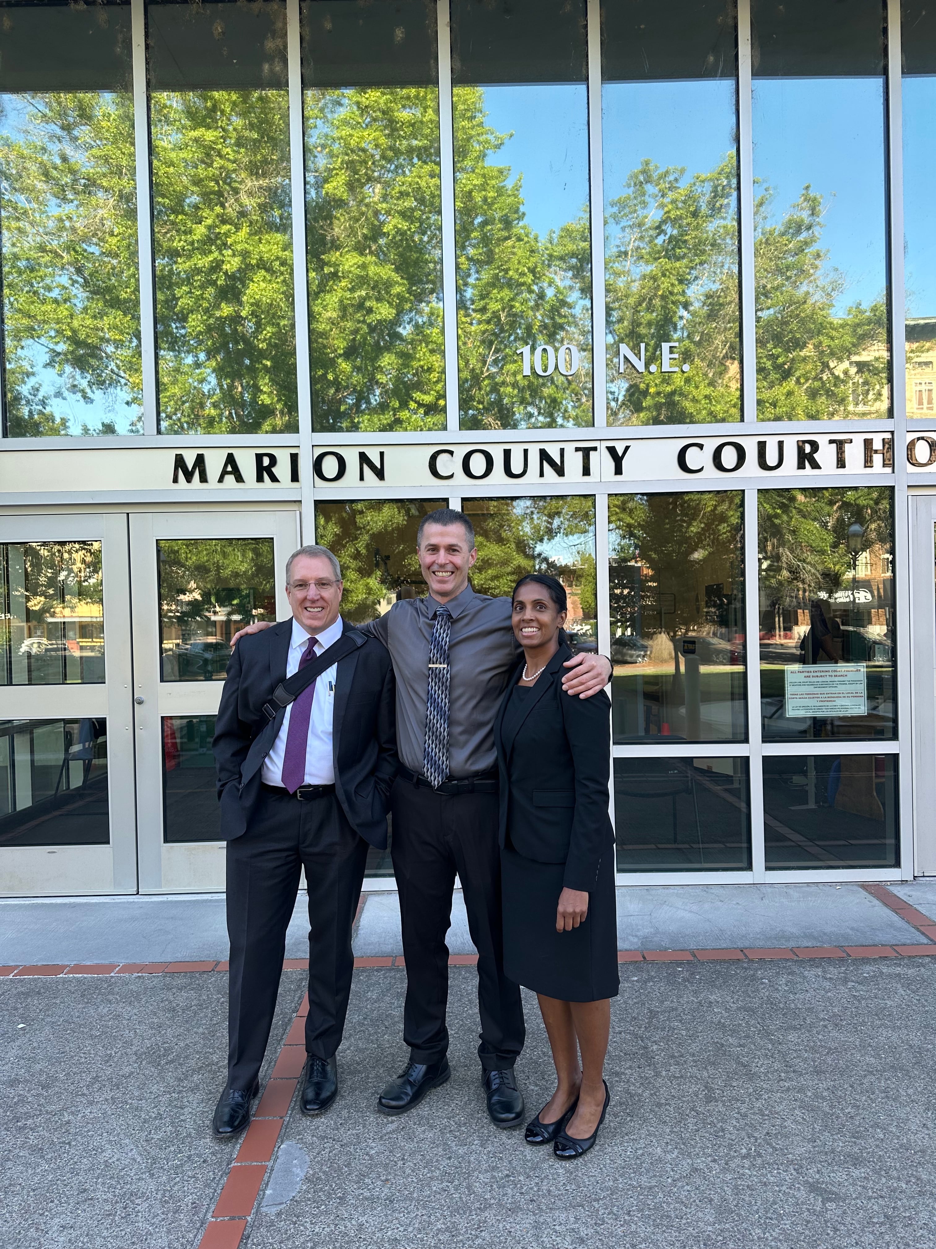 Nicholas McGuffin (center) stands between his attorneys Andrew Lauersdorf (left) and Janis Puracal (right) after a hearing Aug. 1, 2025. An Oregon judge granted McGuffin a certificate of innocence after he was wrongfully convicted for the death of Leah Freeman.