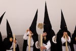 Penitents of Santa Genoveva brotherhood wait before taking part in a procession during Holy Week (Semana Santa) observances on March 30, 2026 in Seville, Spain.
