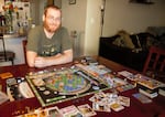 Avid gamer Bryan Fosmire sits at his dining room table in September 2022. He had to revert to playing board games at home after Oregon's Interactive Museum of Gaming and Puzzlery was closed by the COVID-19 pandemic in 2020.