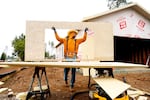 Jose Villanueva carries siding while building a home, Wednesday, Oct. 25, 2023, in Paradise, Calif. Most of the town burned in late 2018.